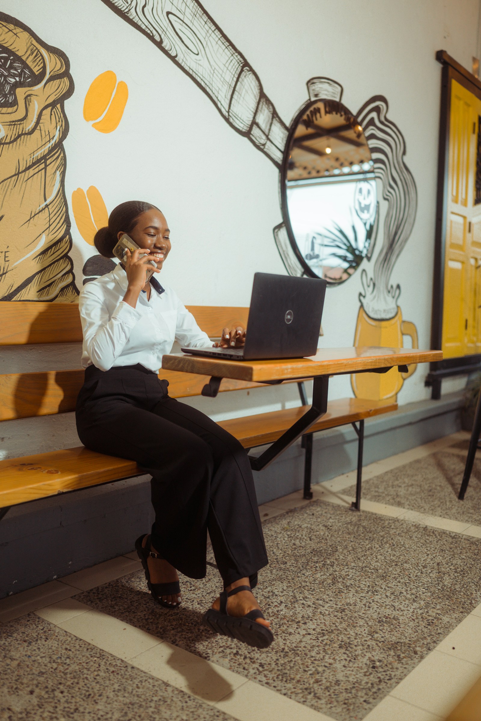 A business owner working from a laptop and phone in a cafe