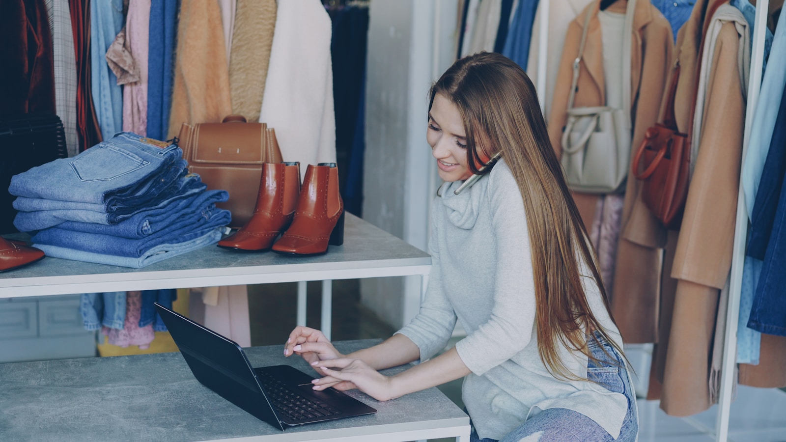 A shop owner working on a laptop between customer jobs